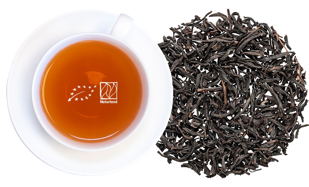 Weiße Tasse Schwarztee mit losen Teeblättern