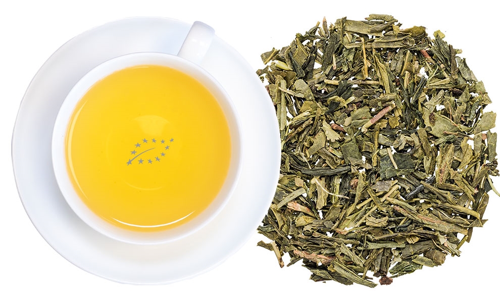 Weiße Tasse mit aufgebrühtem grünem Tee und Blatttee