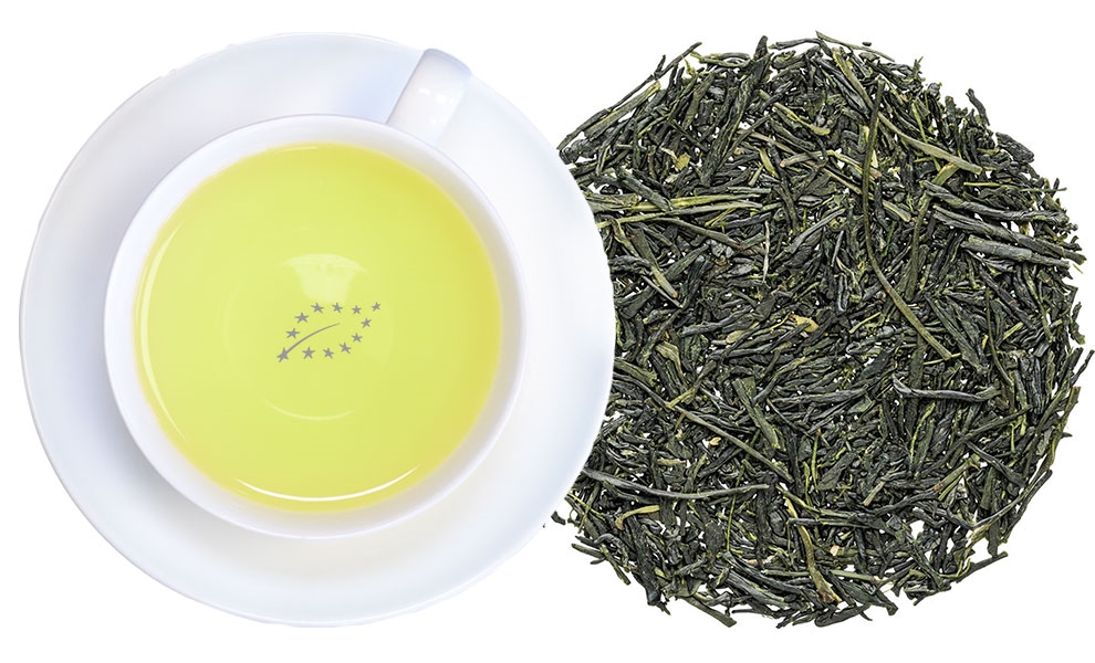Tasse japanischer grüner Tee neben losen Teeblättern