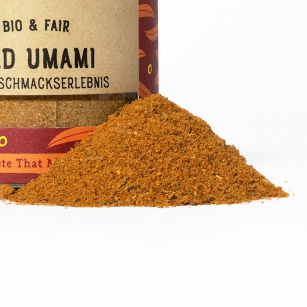 Häufchen der Bio Gewürzmischung Bold Umami vor dem dekorativen Gewürzglas