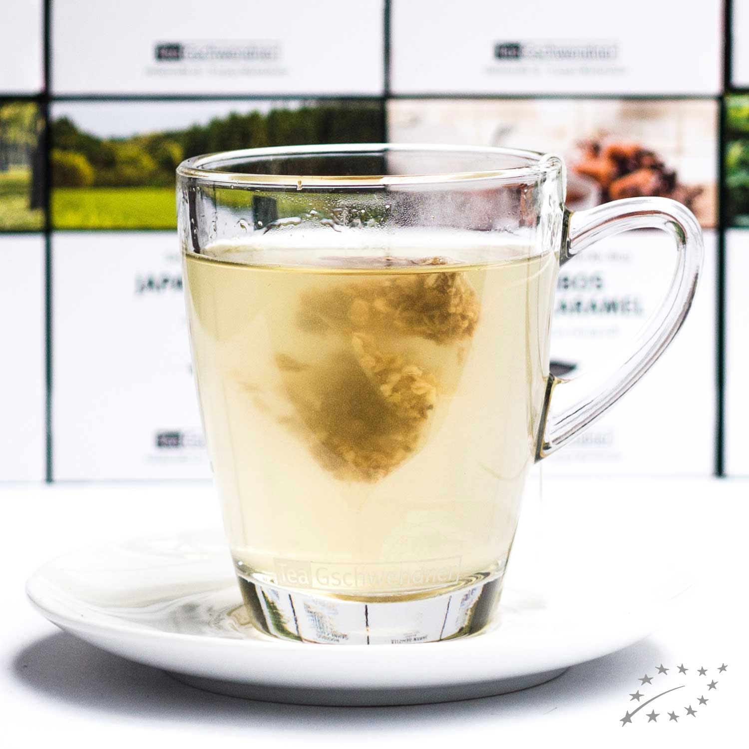 Heißer Kräutertee im Glas auf Unterteller