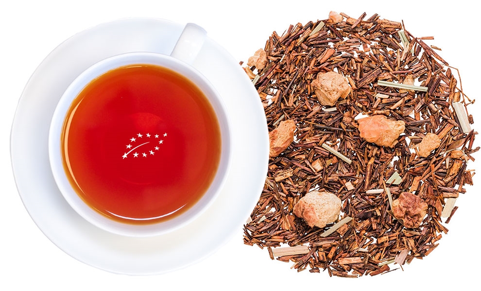 Weiße Tasse Rooibostee neben losem Rooibostee