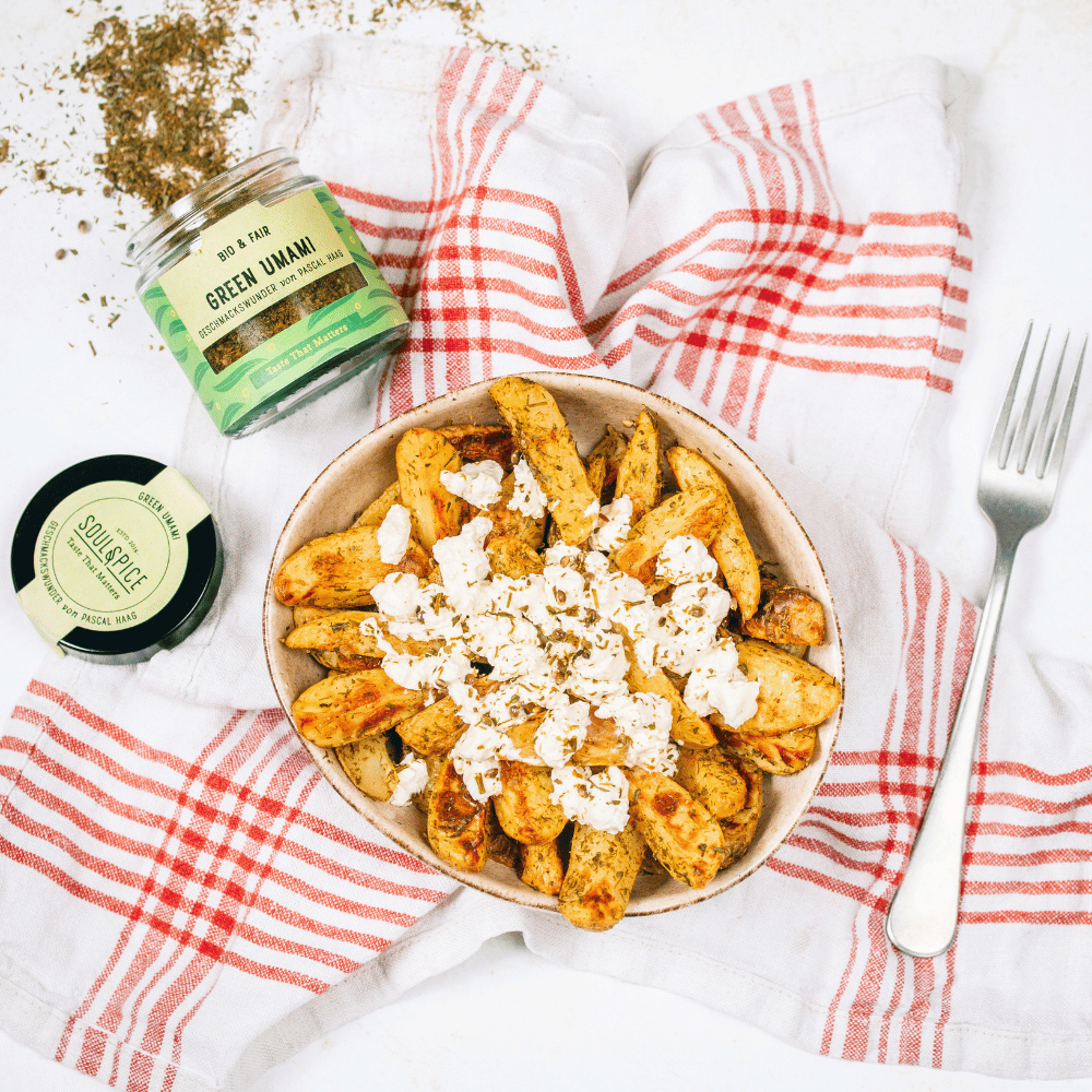 Schüssel mit knusprigen Ofenkartoffeln, mit Feta und SoulSpice Green Umami Bio-Gewürzmischung auf Geschirrtuch angerichtet