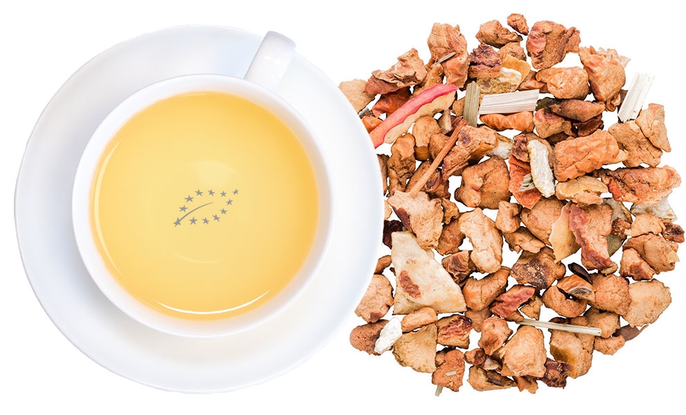 Weiße Tasse Früchtetee neben losen Trockenfrüchten