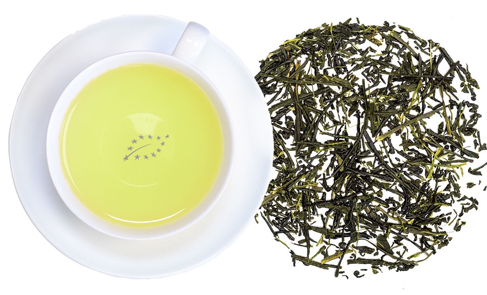 Weiße Tasse mit grünem Tee und losem Grüntee-Blatt