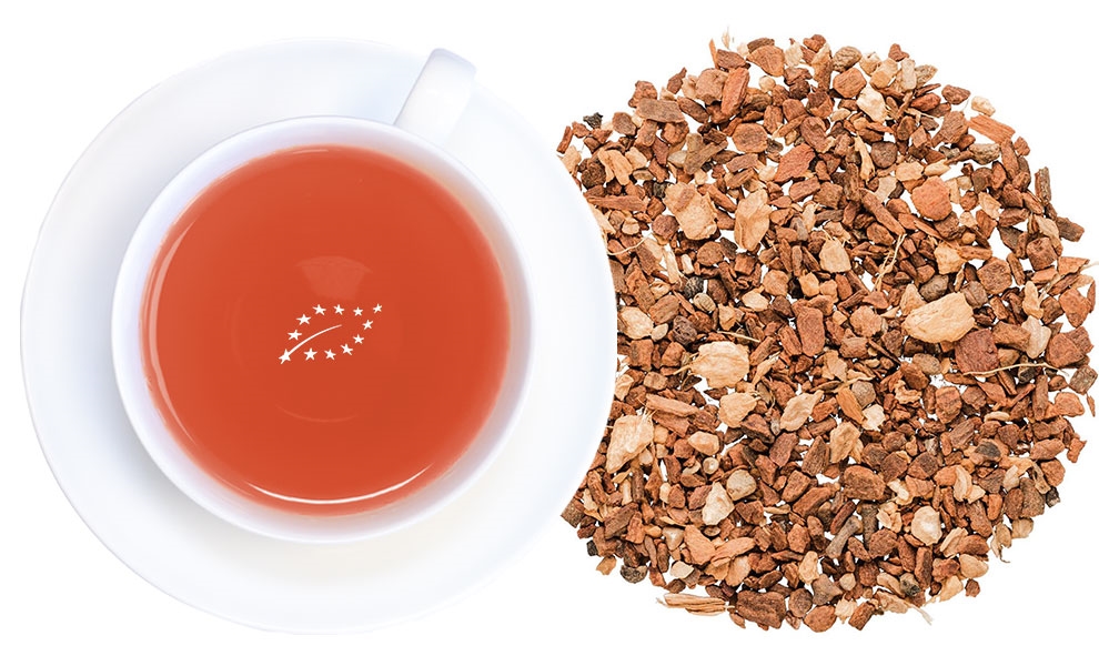 Weiße Tasse mit Gewürztee neben loser Teemischung