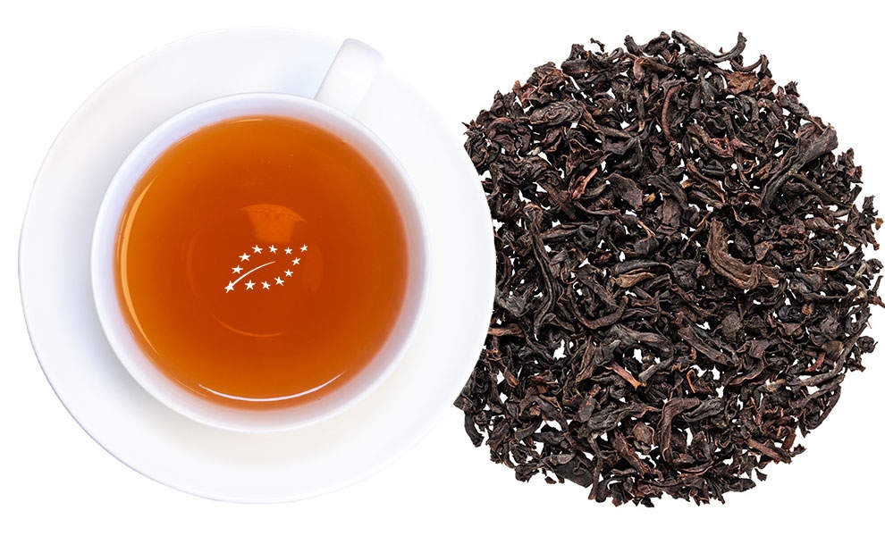 Weiße Tasse mit Schwarzem Tee und losem Schwarztee