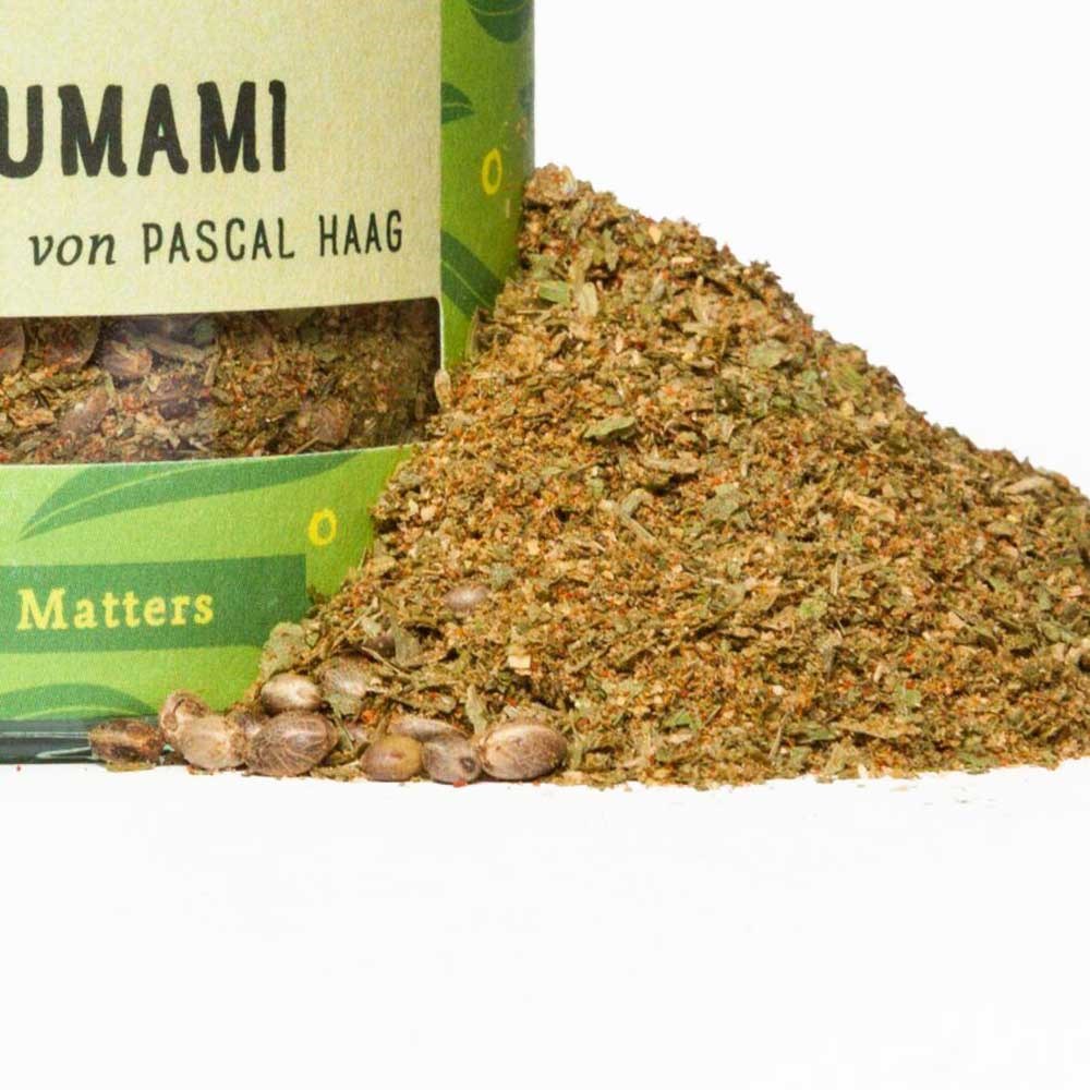 Großaufnahme einer geöffneten Dose mit Umami Gewürzmischung von Pascal Haag, daneben ein Haufen des groben Kräuter- und Gewürzpulvers