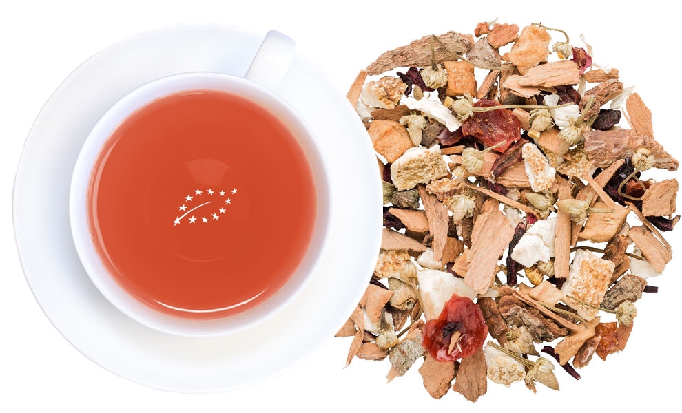 Weiße Tasse Früchtetee neben loser Teemischung