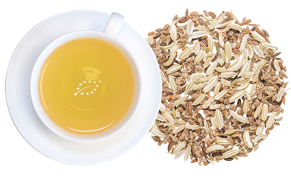 Weiße Tasse Fenchel-Anis-Kümmel-Tee neben Samen