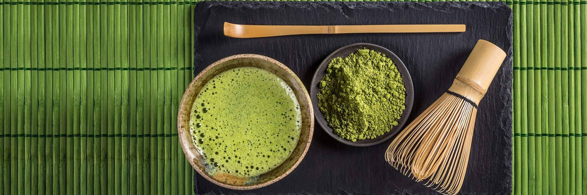 Grüner Matcha Tee und Matcha Pulver mit Bambusbesen