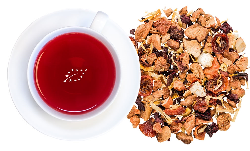 Rote Tasse Früchtetee neben loser Früchteteemischung