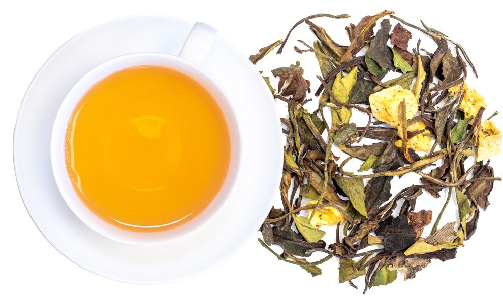 Weiße Teetasse mit aufgebrühtem Weißtee und losen Blättern
