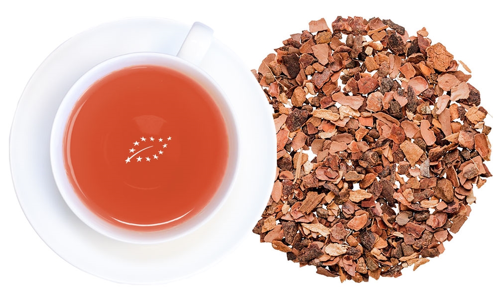 Weiße Tasse Kakaoschalentee neben Kakaoschalen