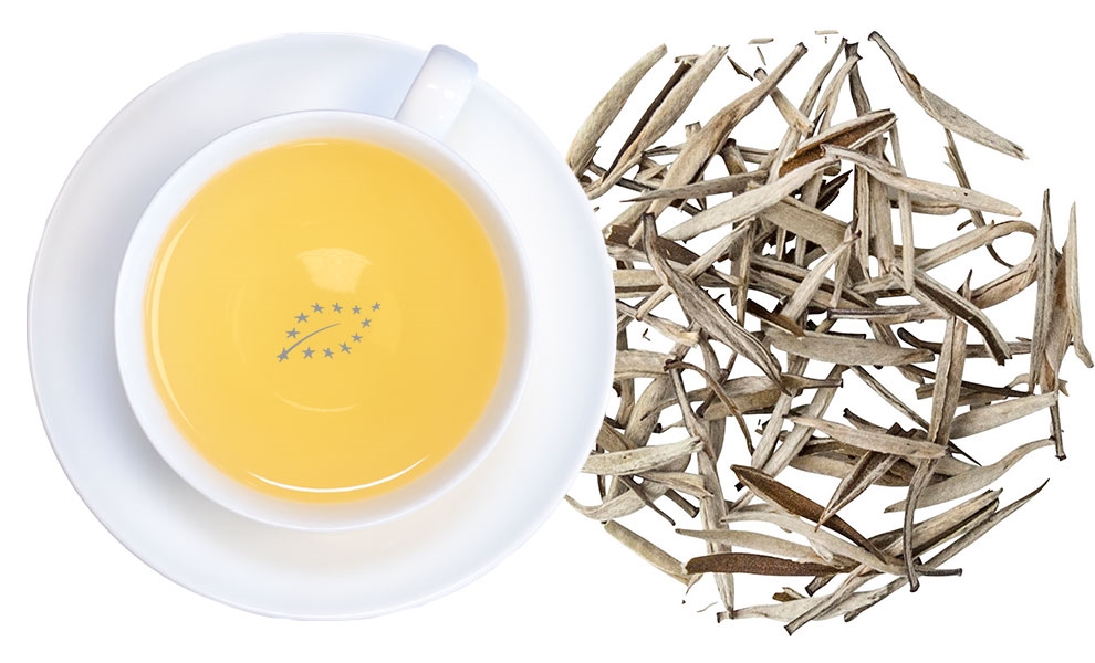 Weiße Teetasse mit aufgebrühtem Weißtee und Blättern