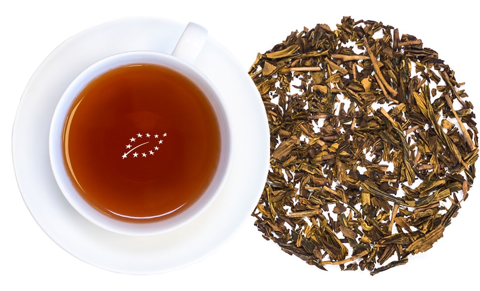 Weiße Tasse grüner Tee mit losen Teeblättern