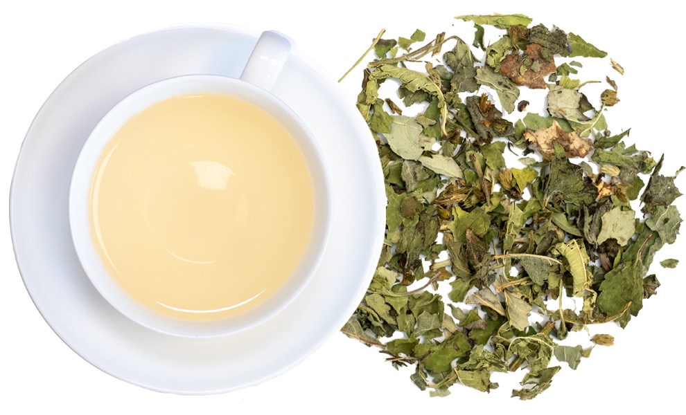 Weiße Tasse mit hellem Kräutertee und losen Blättern