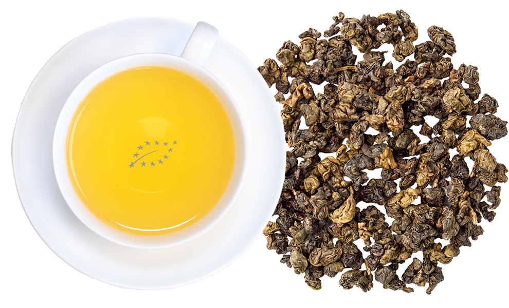 Weiße Tasse mit gelbem Tee neben losem Oolong-Tee
