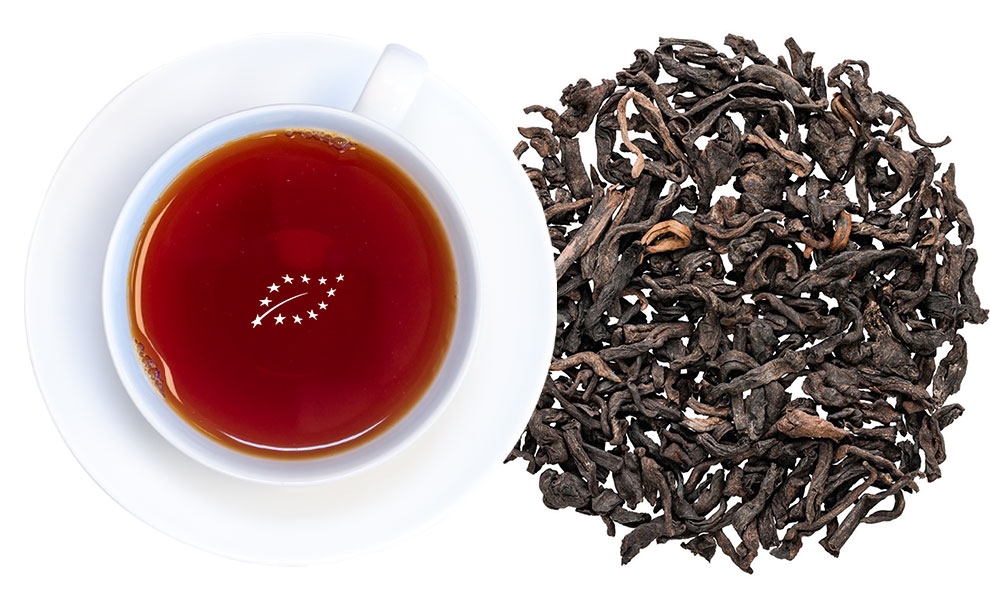 Weiße Tasse Schwarztee mit losen Schwarzteeblättern