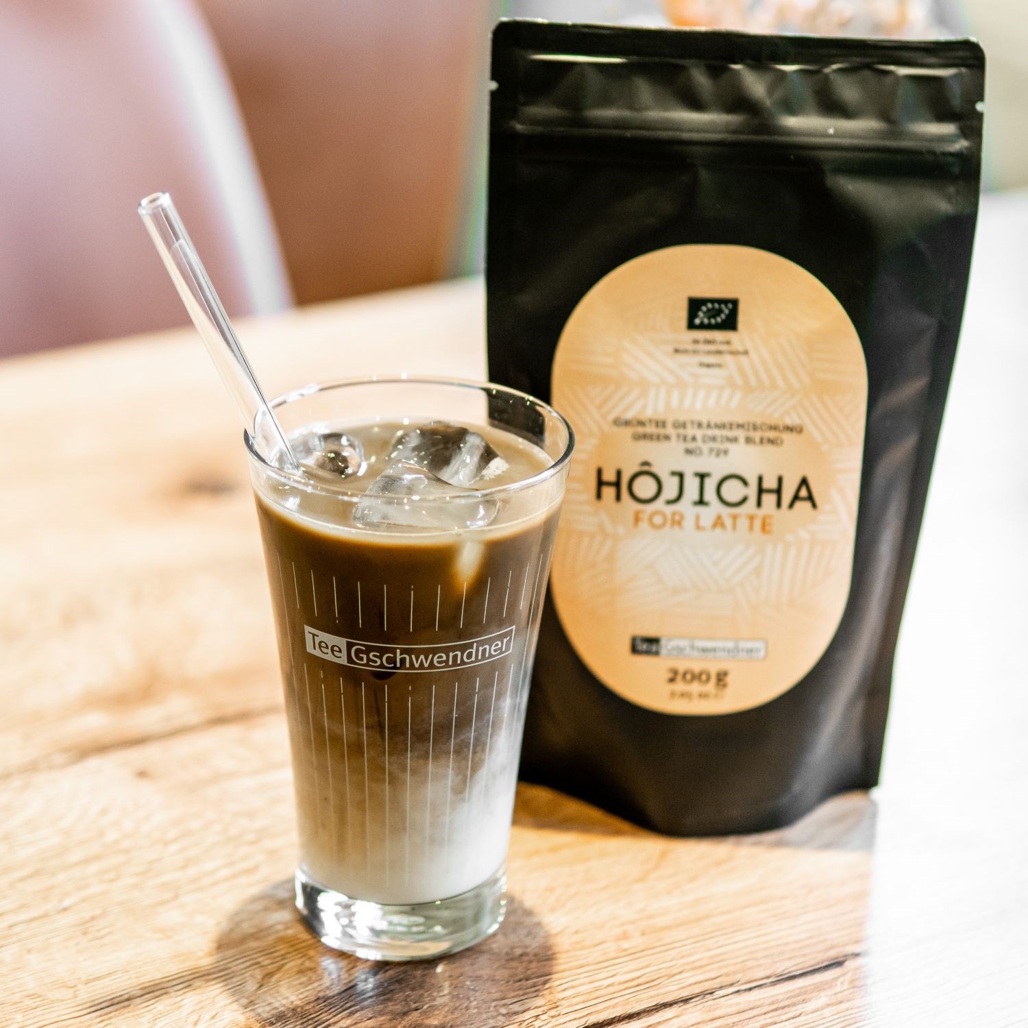 Glas Hojicha Eistee-Latte mit Teepackung