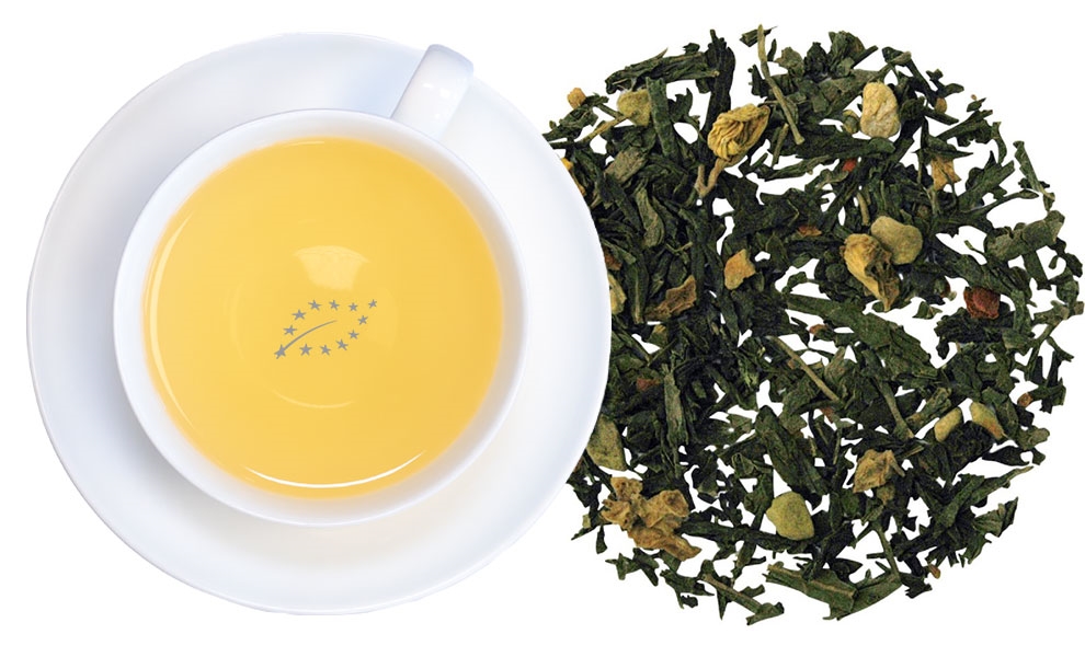 Tasse grüner Tee mit Ingwerstücken lose daneben