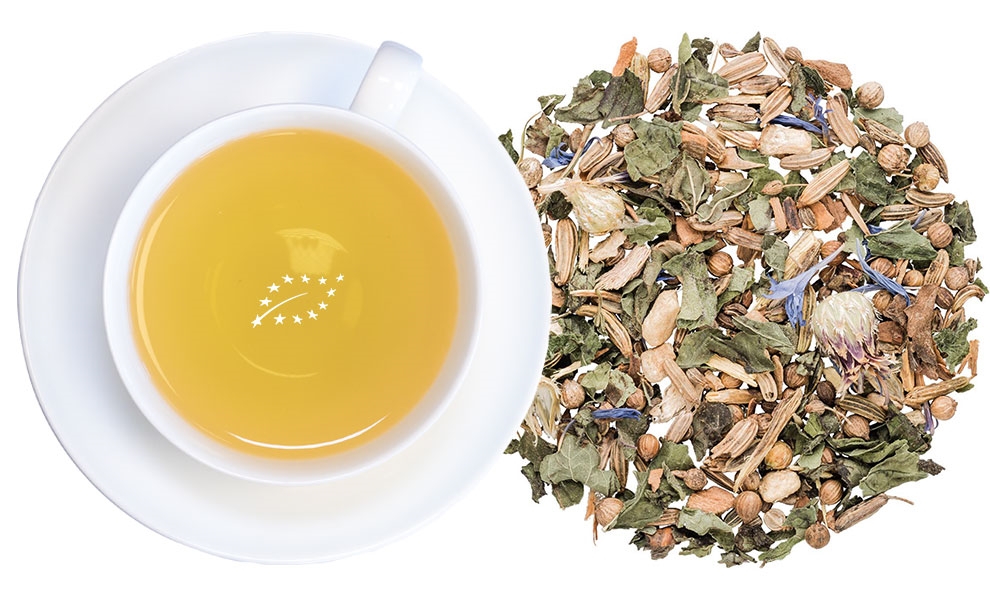 Weiße Tasse Kräutertee neben loser Kräutermischung