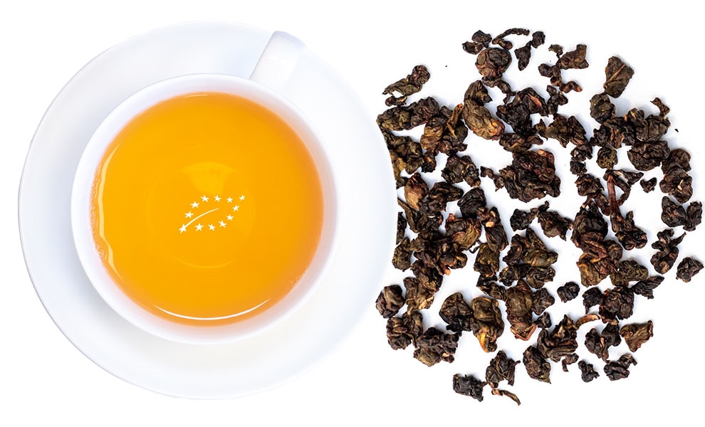 Tasse mit Oolong-Tee und trockenen Teeblättern