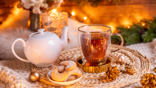 Teekanne und Teetasse auf Tisch mit weihnachtlicher Deko