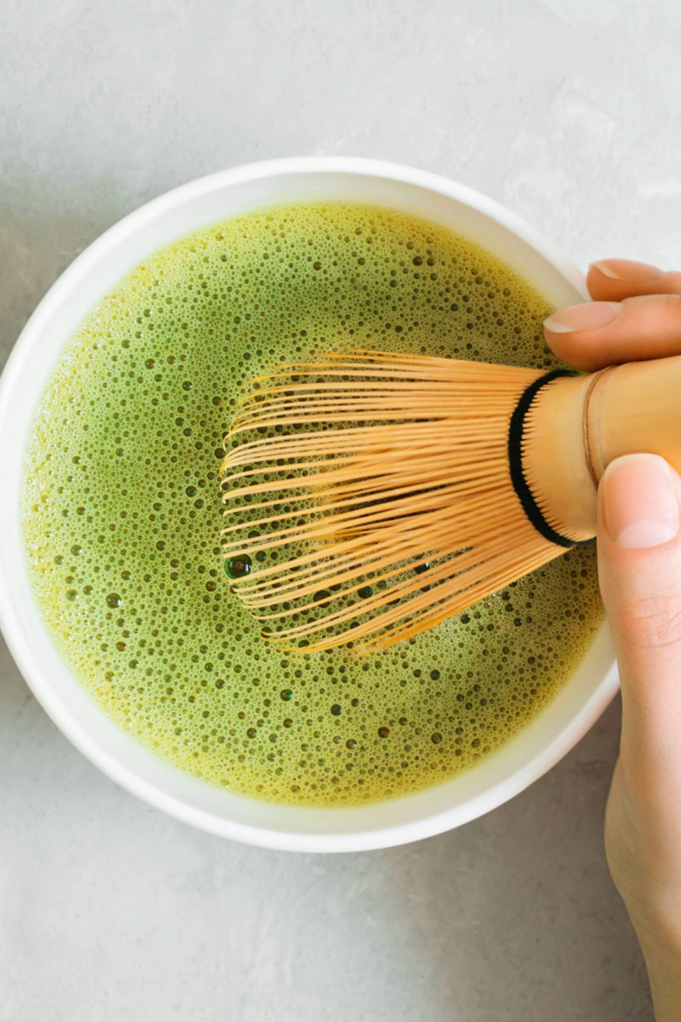 Matcha Tee in Schale mit Bambusbesen gerührt
