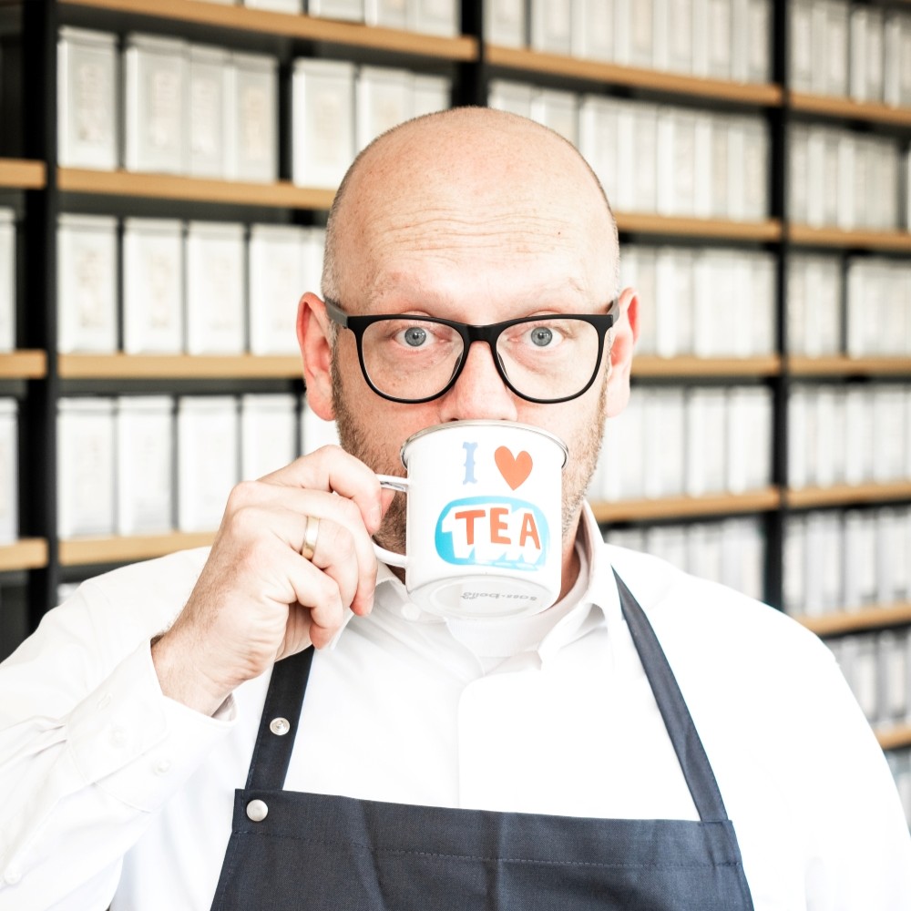 Mann mit Brille trinkt aus Tasse I Love Tea
