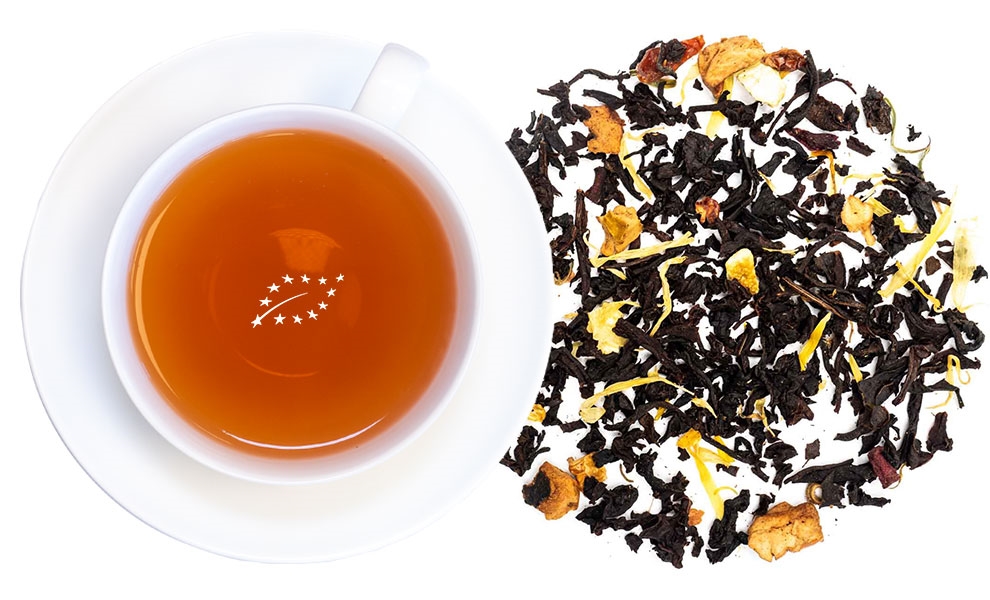 Weiße Tasse Schwarztee neben Früchtetee-Mischung