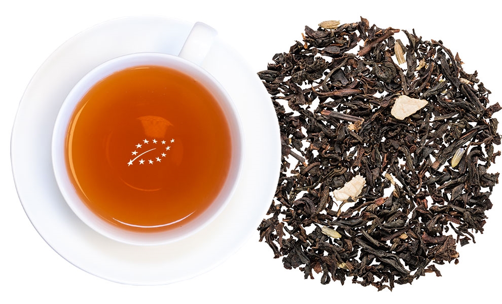 Weiße Tasse mit schwarzem Tee und losen Teeblättern